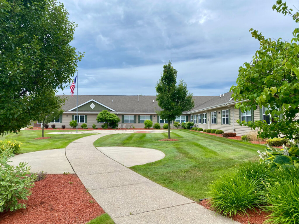 Curved walking path through manicured lawn and landscaping at Traditions of Saginaw.