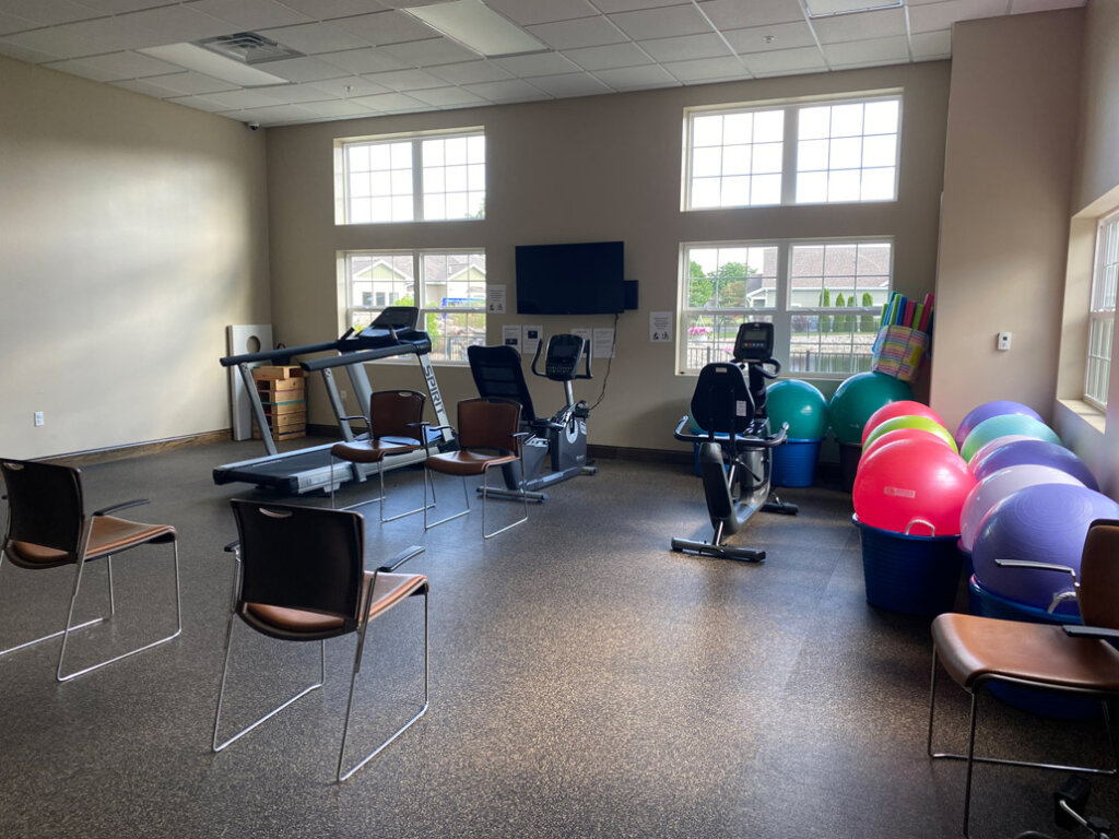 Fitness room with exercise bikes and stability balls at Traditions of Saginaw senior community.