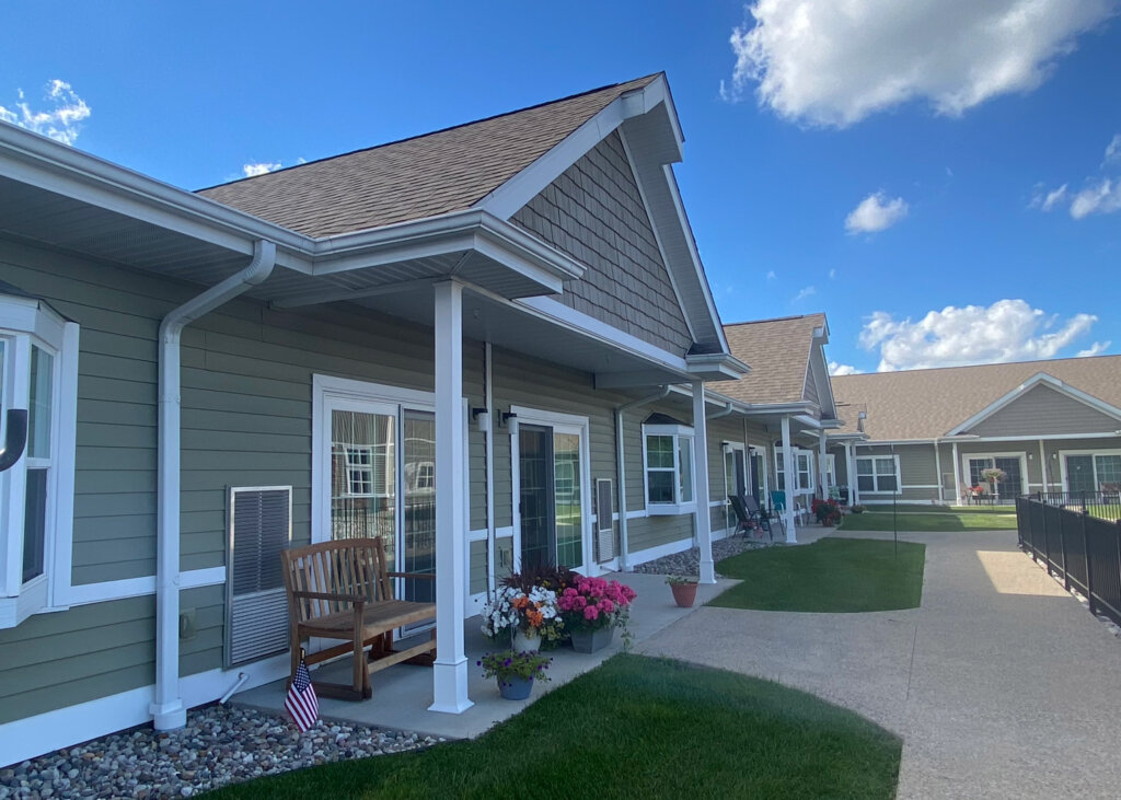 Row of resident porches and private entrances with landscaped walkway at Traditions of Saginaw.