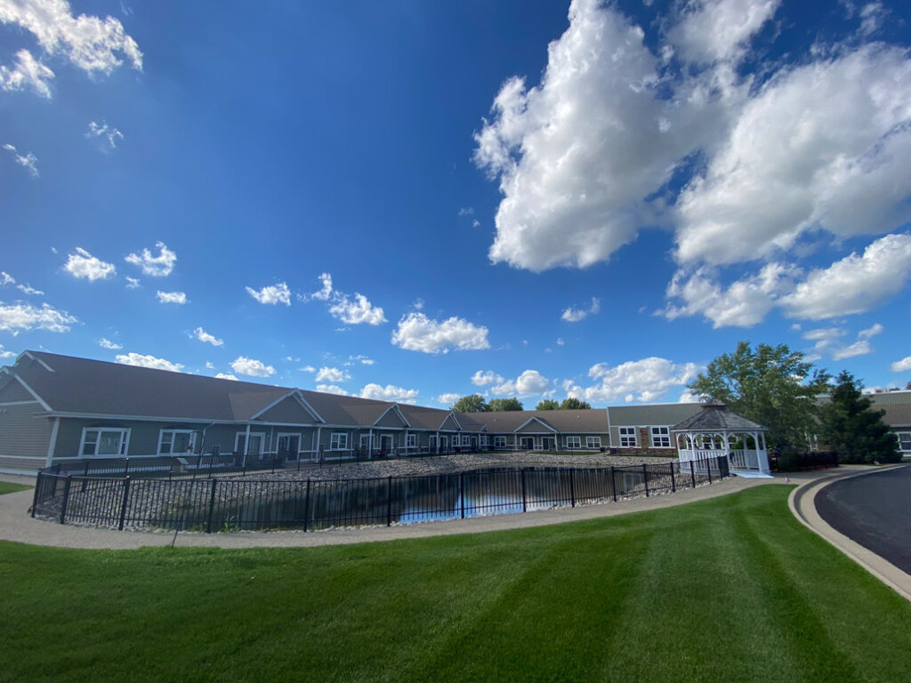 Resident buildings and roadway with black fencing at Traditions of Saginaw Senior Living.