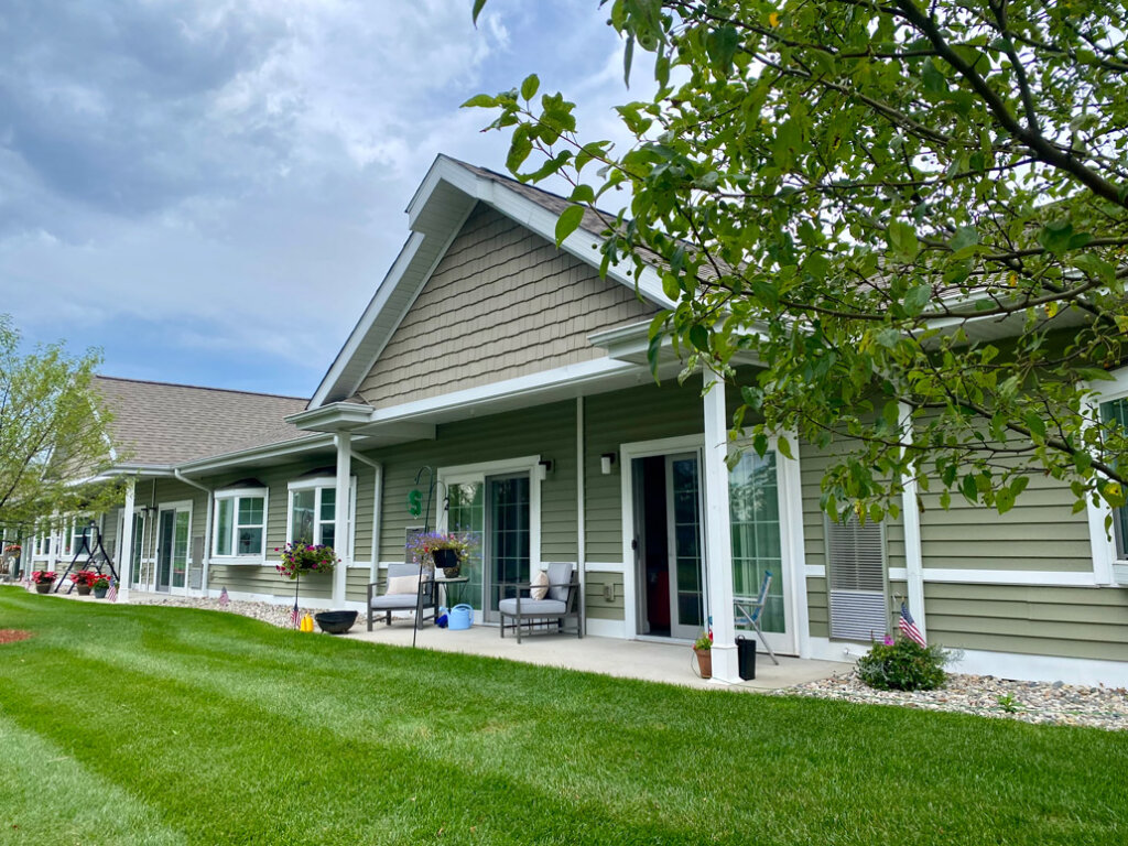 Senior living residence exterior with covered patio and landscaping at Traditions of Saginaw.