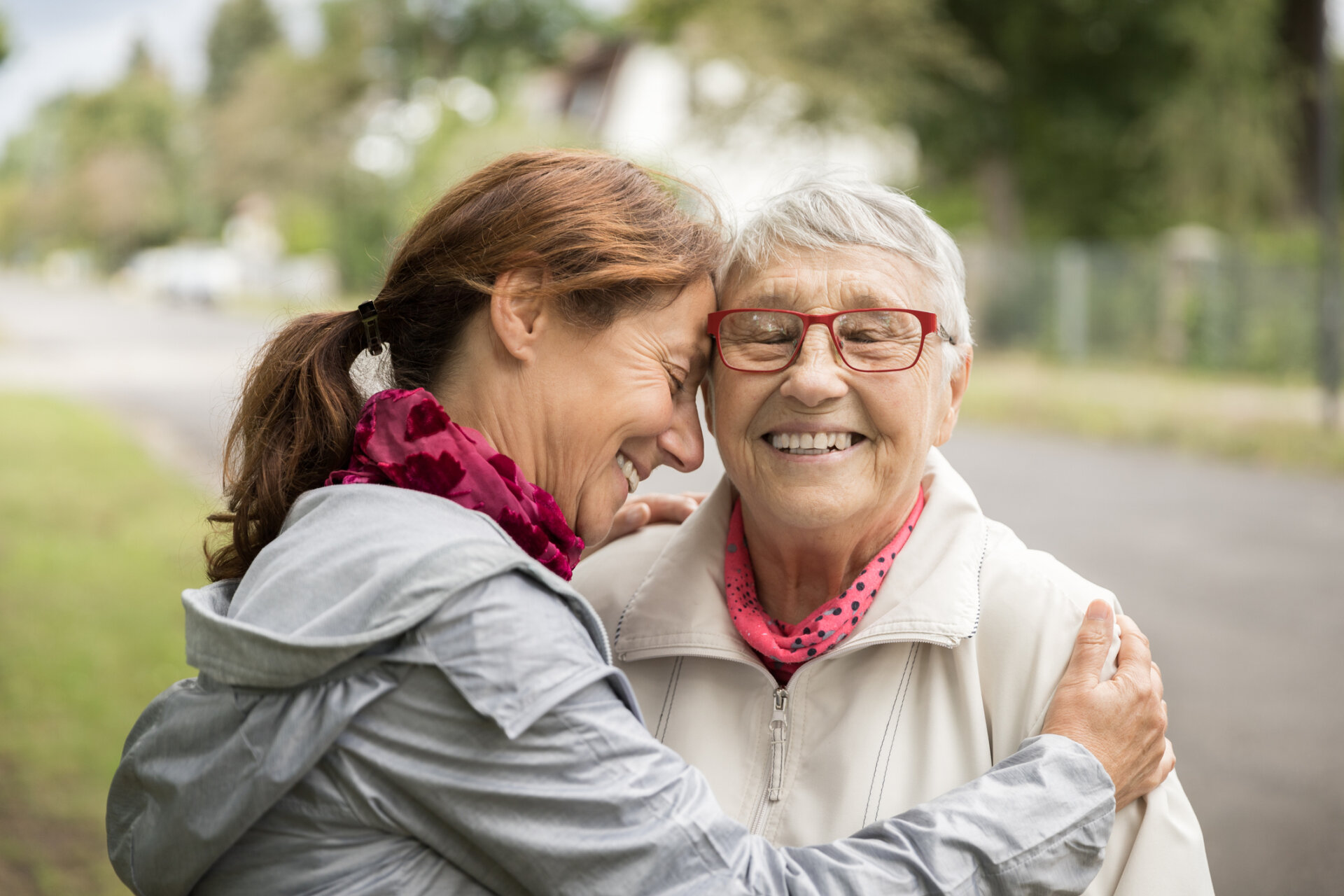 Happy senior woman and adult daughter walking outdoors and smiling together. Traditions at Saginaw in Saginaw, MI.