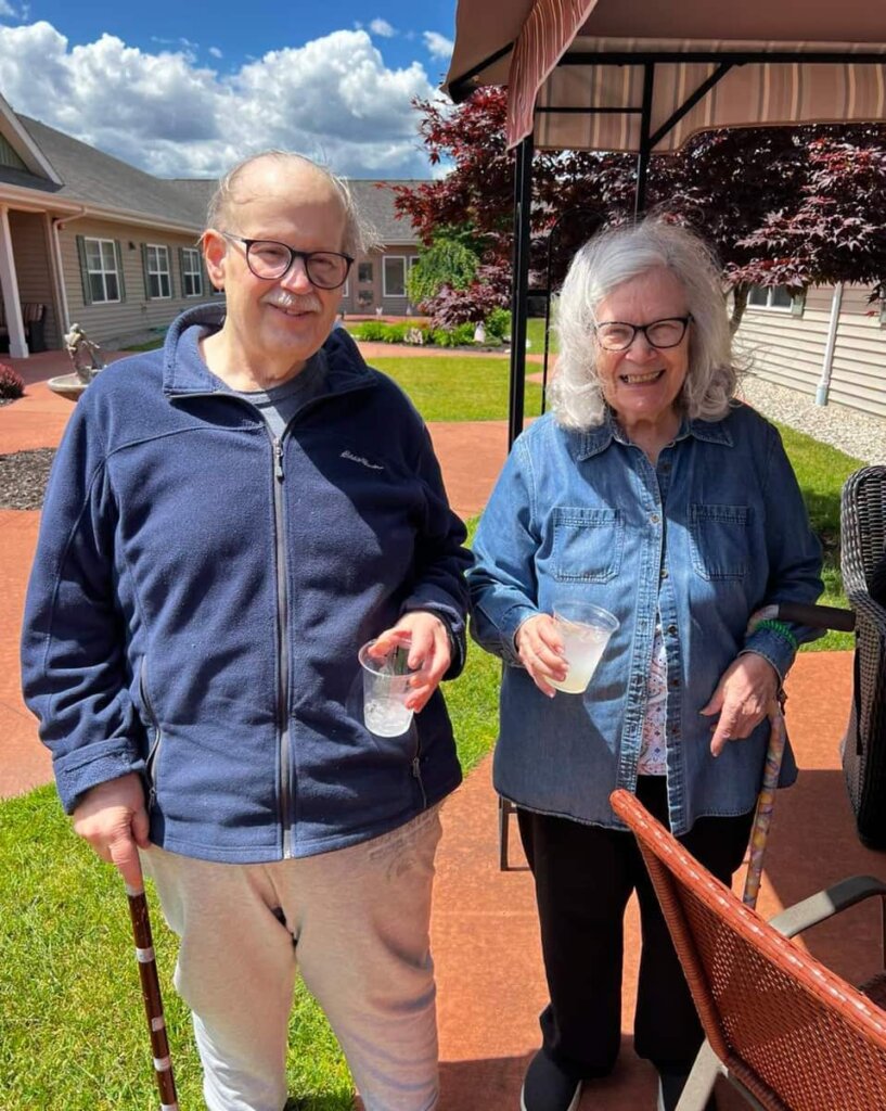 Two residents hold cups of lemonade in the courtyard at Traditions of Saginaw in Saginaw, Michigan.